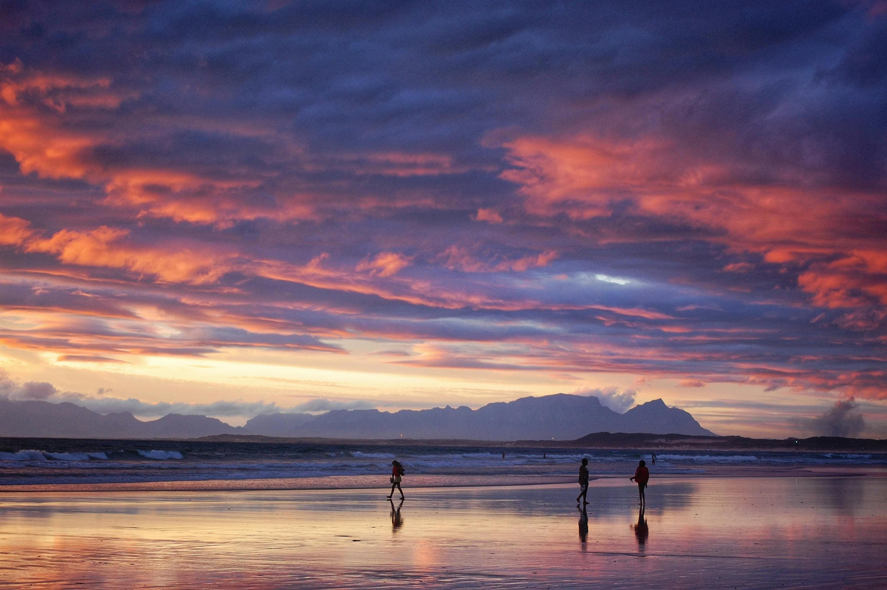 Pink sunset on Bloubergstrand Beach with silhouettes